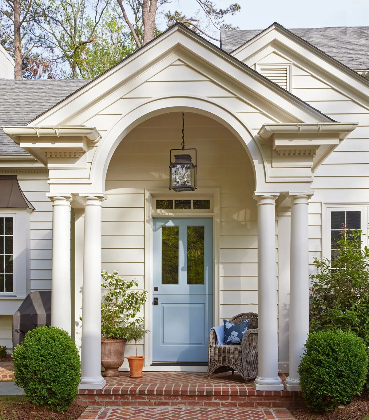 Arched portico with columns framing a blue front door