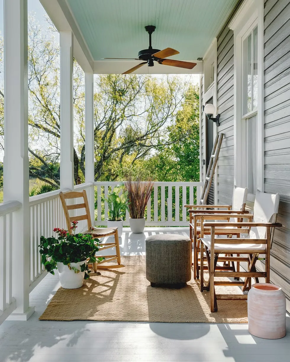 Covered porch with rocking chairs and a blue ceiling over a jute rug