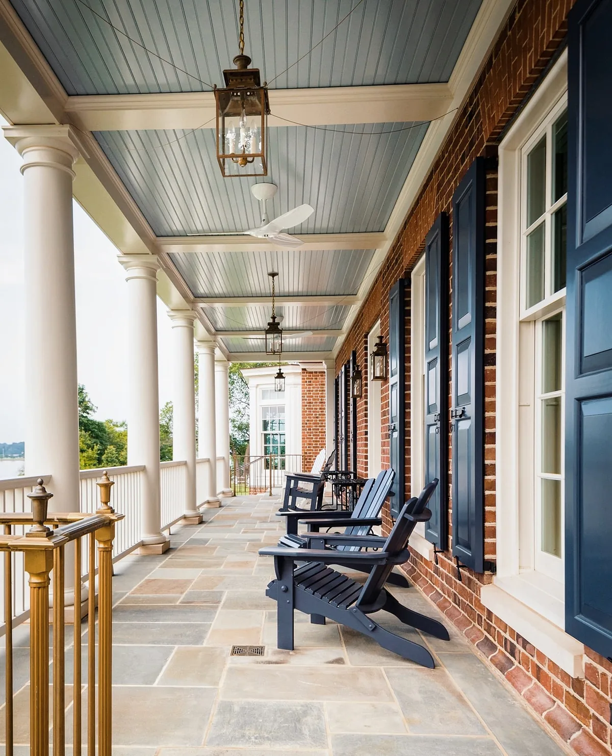 Porch with a blue ceiling and Adirondack chairs in afternoon light