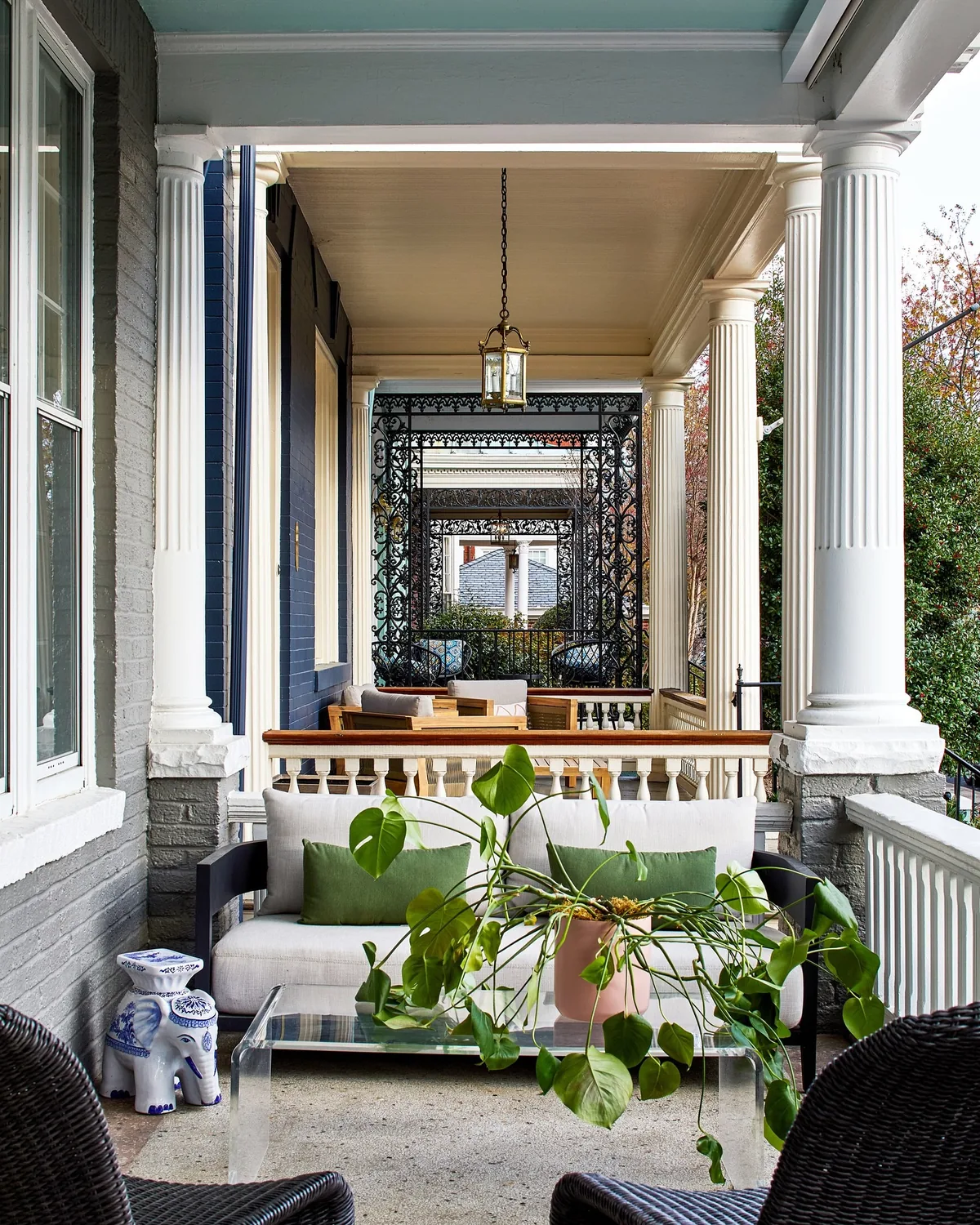 Classic columned porch with a blue ceiling and a sheltered sofa