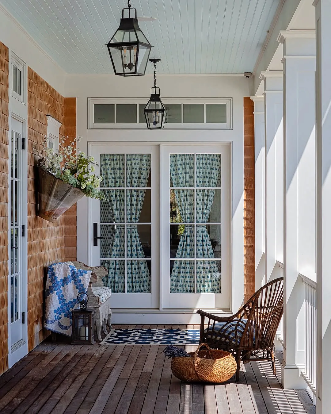 Brick porch with French doors and a wicker bench