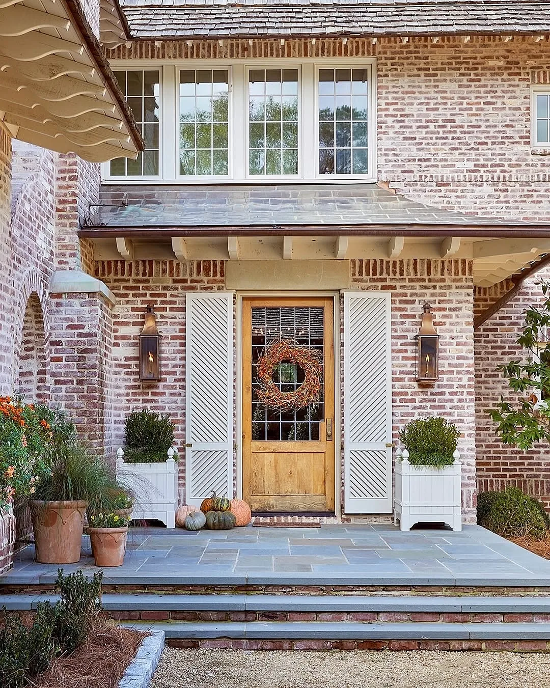 Rustic brick front porch with simple seasonal decor