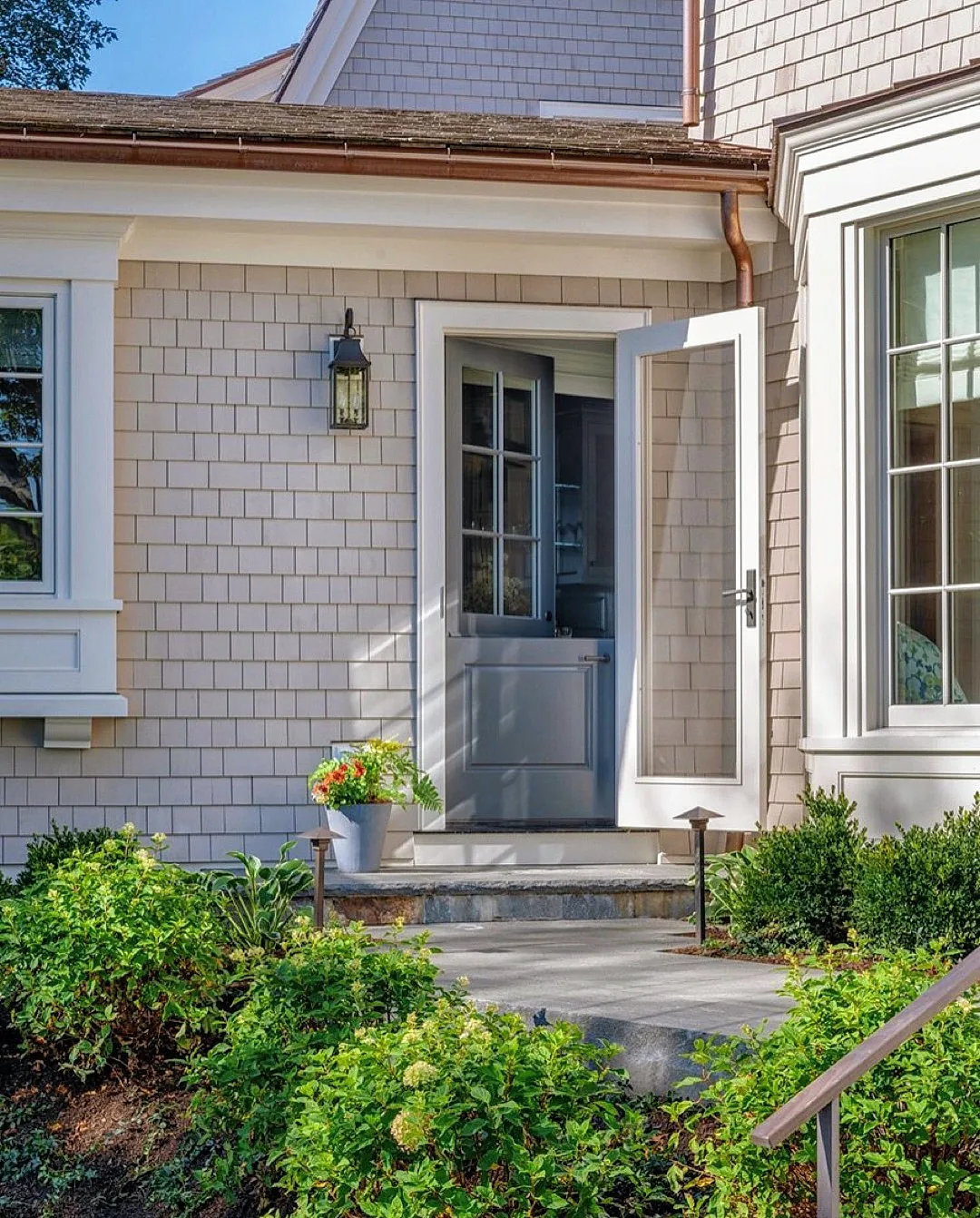 Shingle house with a gray Dutch door and a stone step
