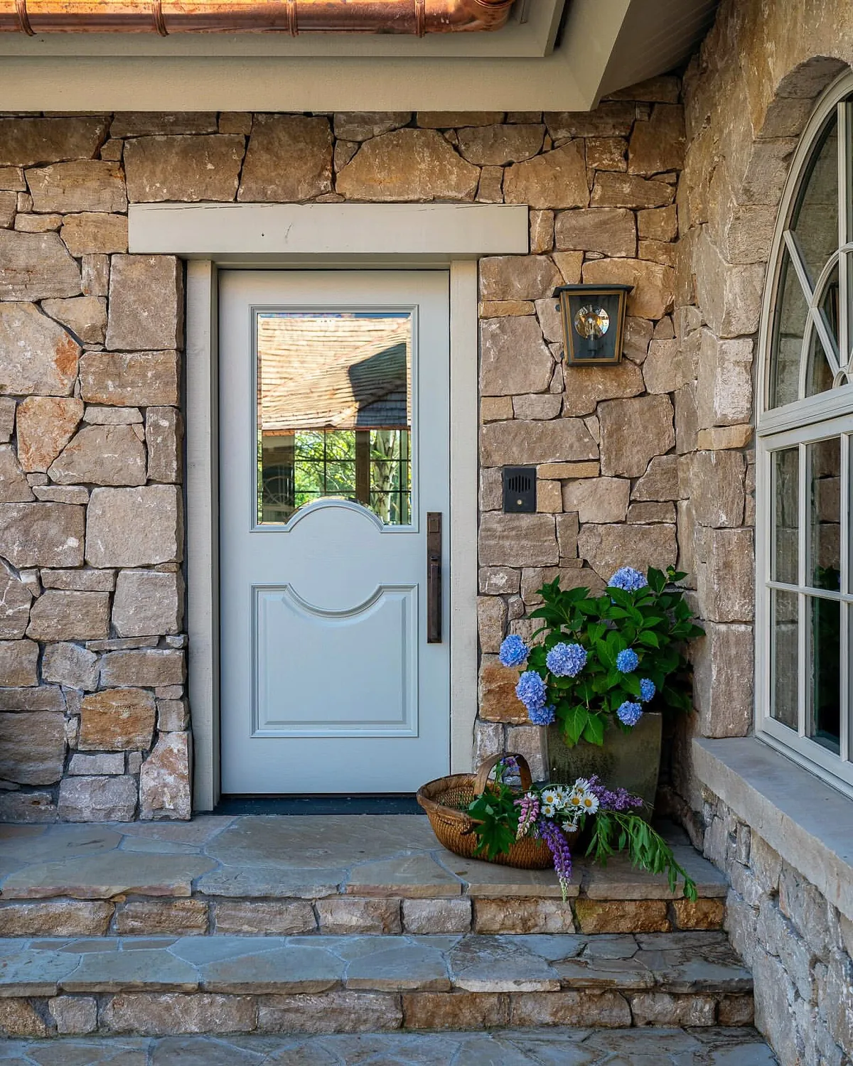 Stone house with a white front door and slate steps