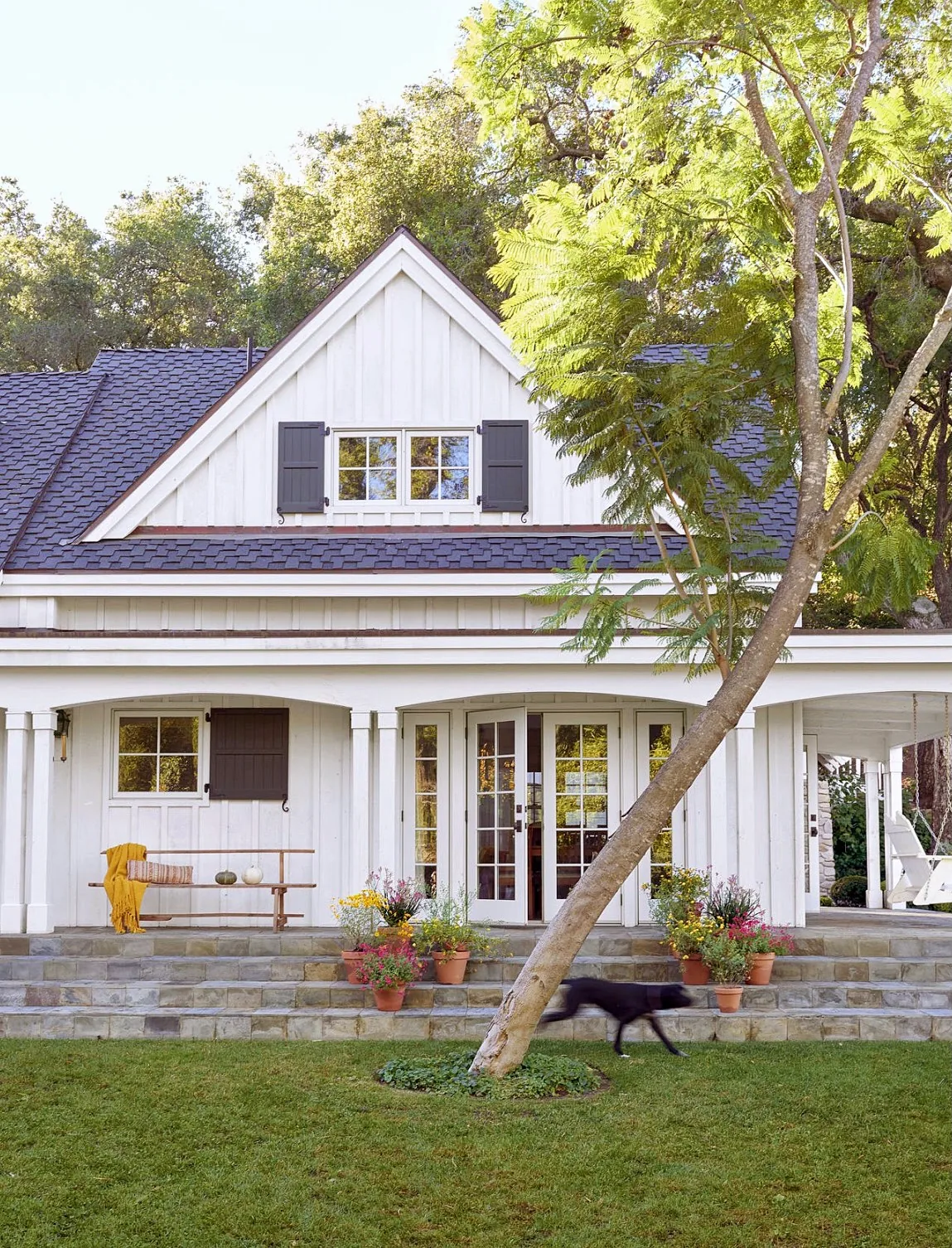 White board and batten porch with stone steps leading up
