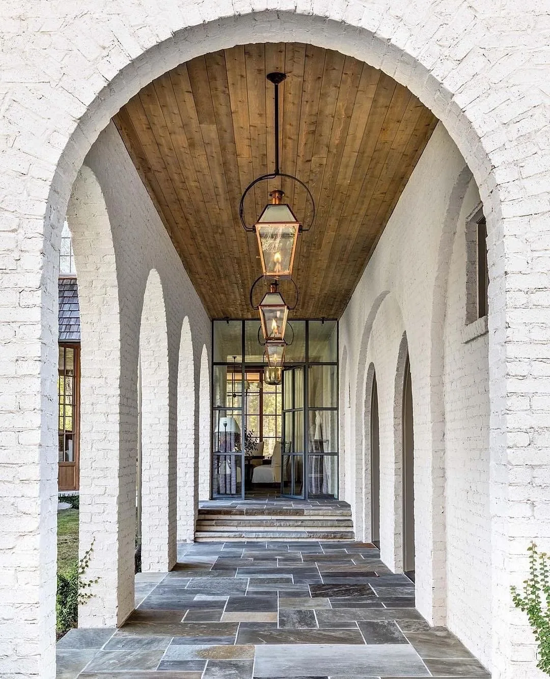 White brick arcade with a slate floor and lanterns