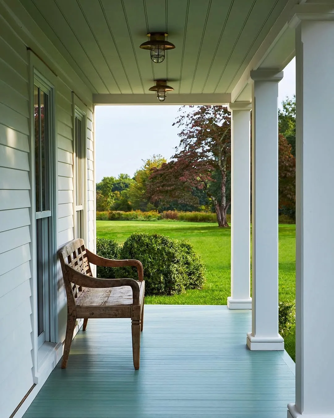 Cozy farmhouse front porch with layered decor and seating