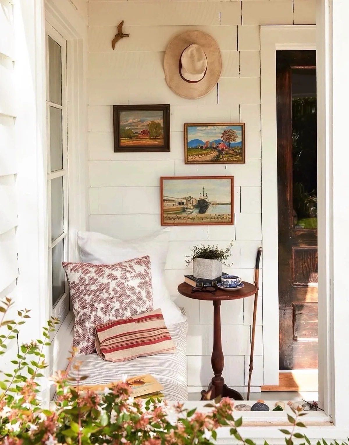 Cozy farmhouse porch sitting area with chairs and soft textiles