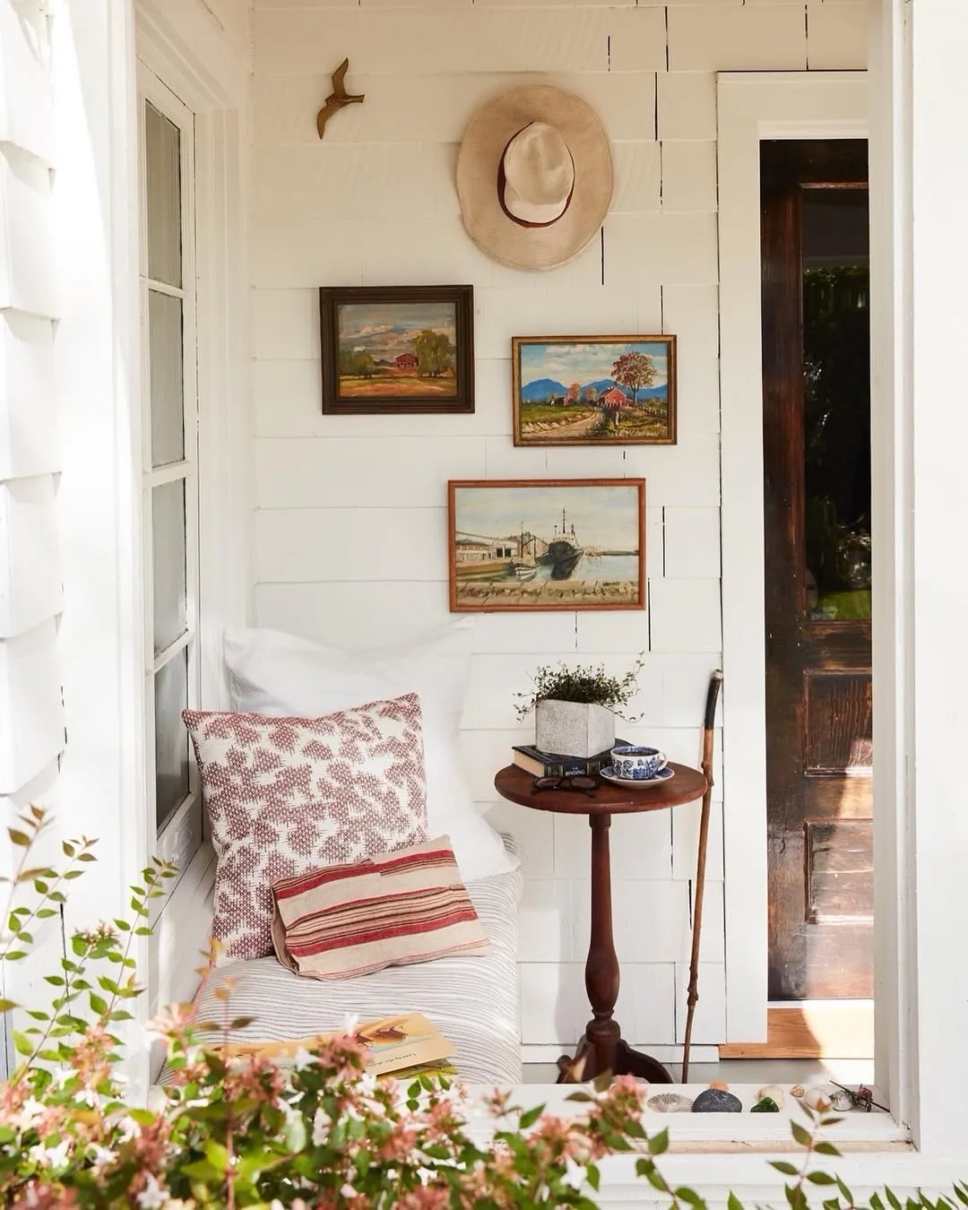 Farmhouse porch with a vintage gallery wall of collected frames