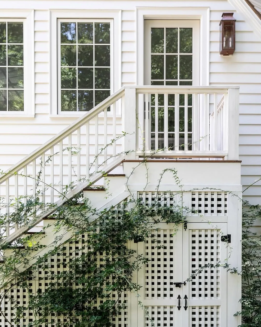White porch lattice with climbing vines softening the skirting