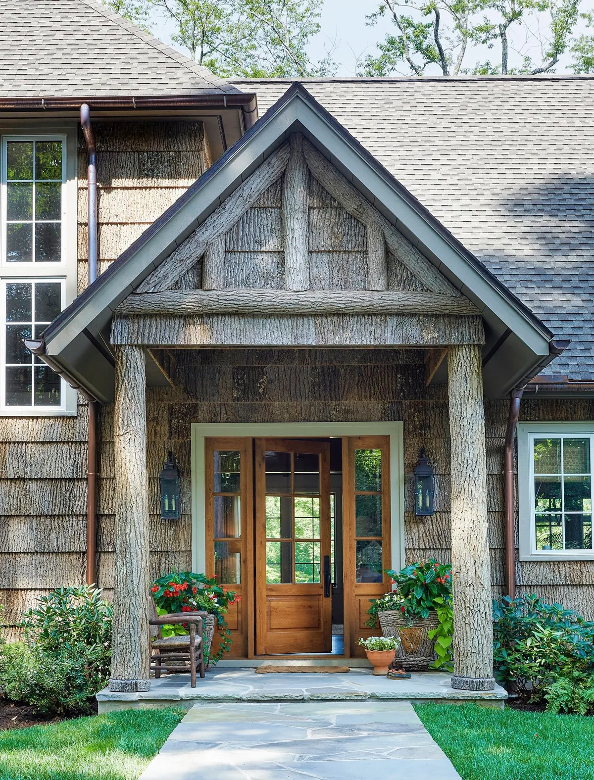 Shingle cottage with a cedar column portico sheltering the entry