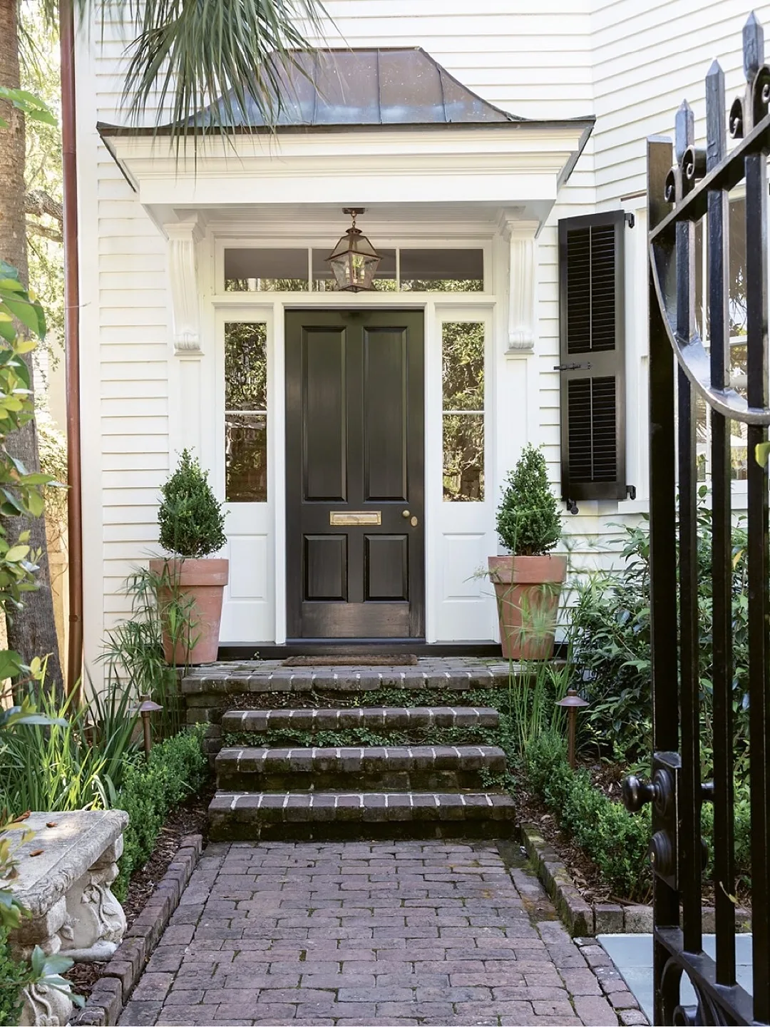 White clapboard portico with brick steps centered on the door