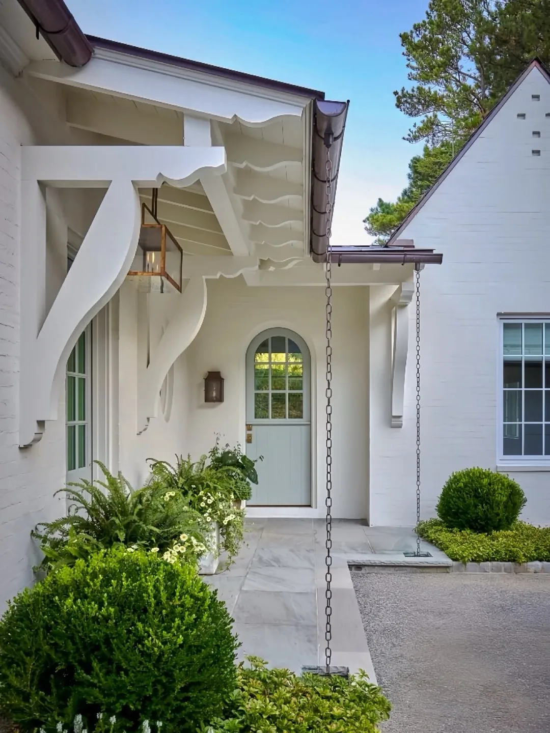 White brick entry with a scrolled bracket and a mint green door