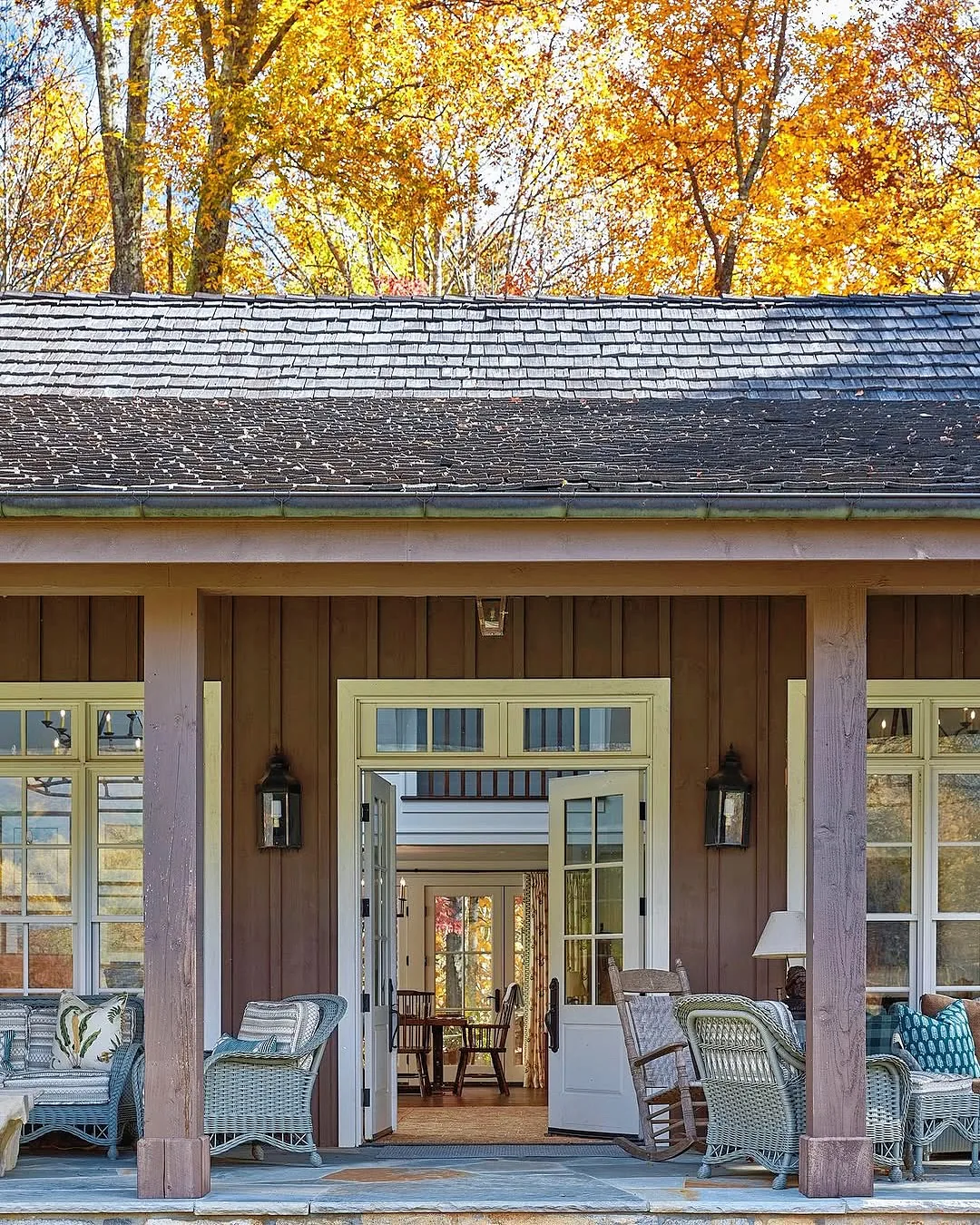 Cedar shingle porch with wicker rockers and autumn planters