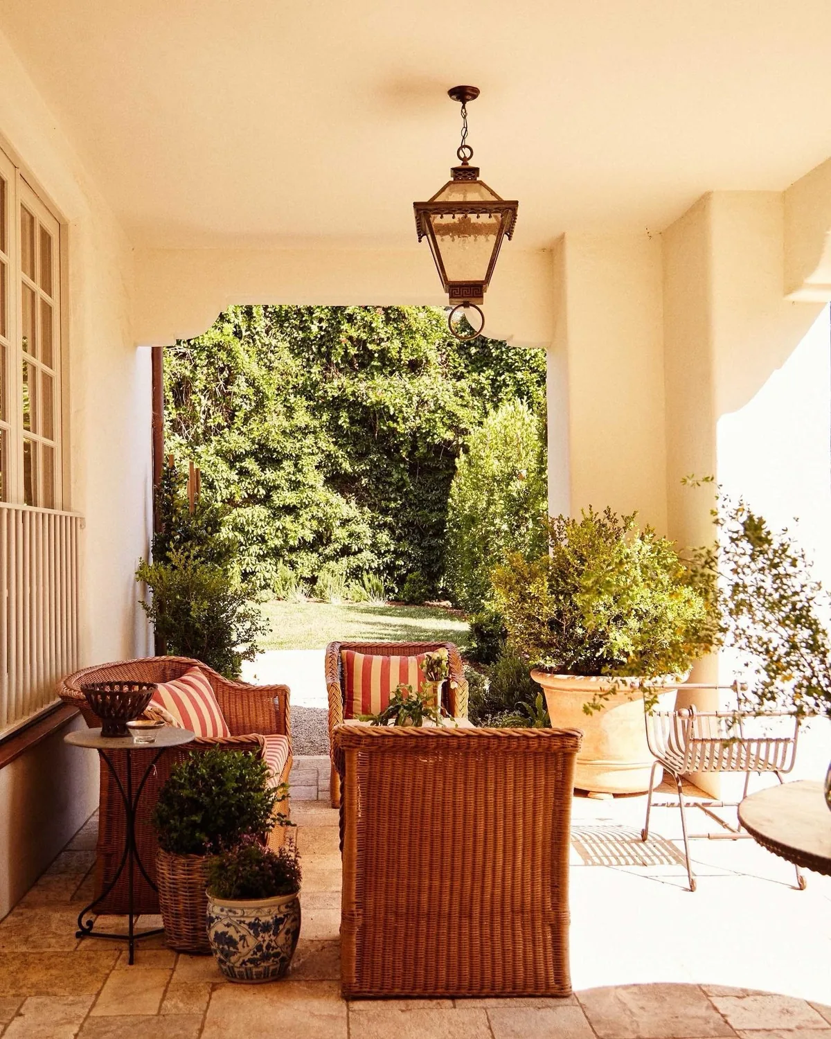 Cream porch with wicker chairs and a glowing lantern
