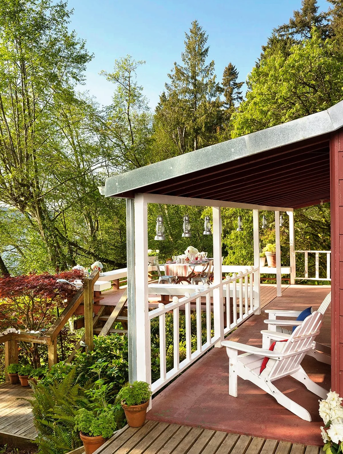 Red barn porch with white Adirondack chairs facing the view