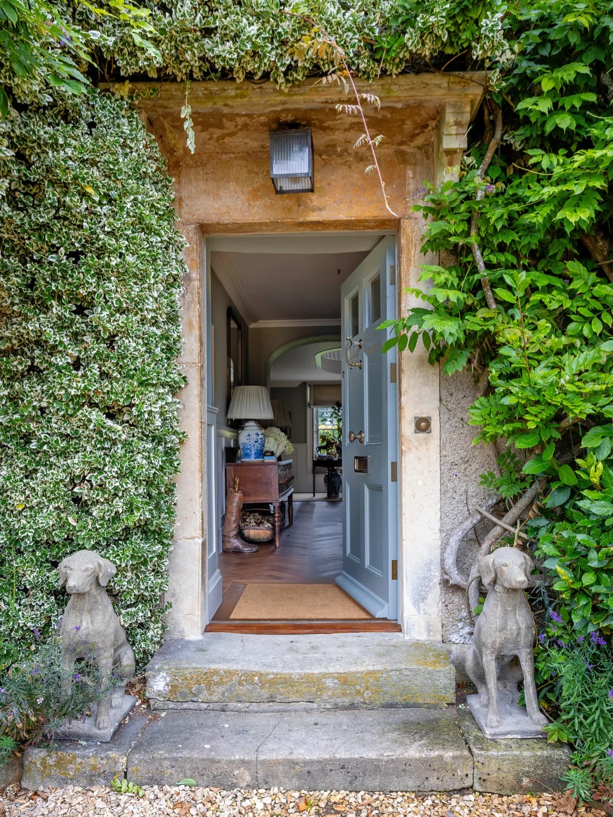 Ivy-covered doorway with stone dog statues guarding the entry