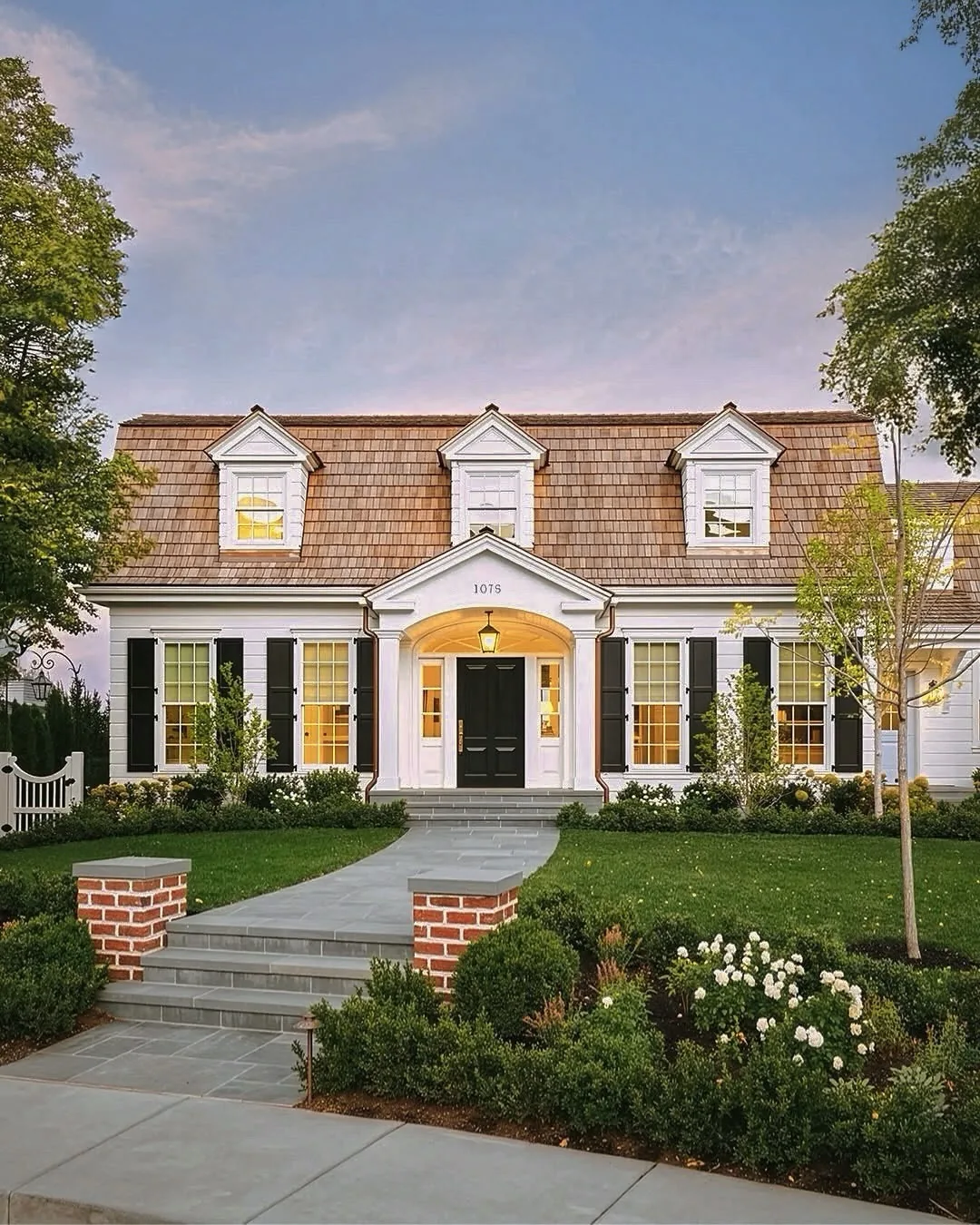 White Cape Cod with black shutters and dormers
