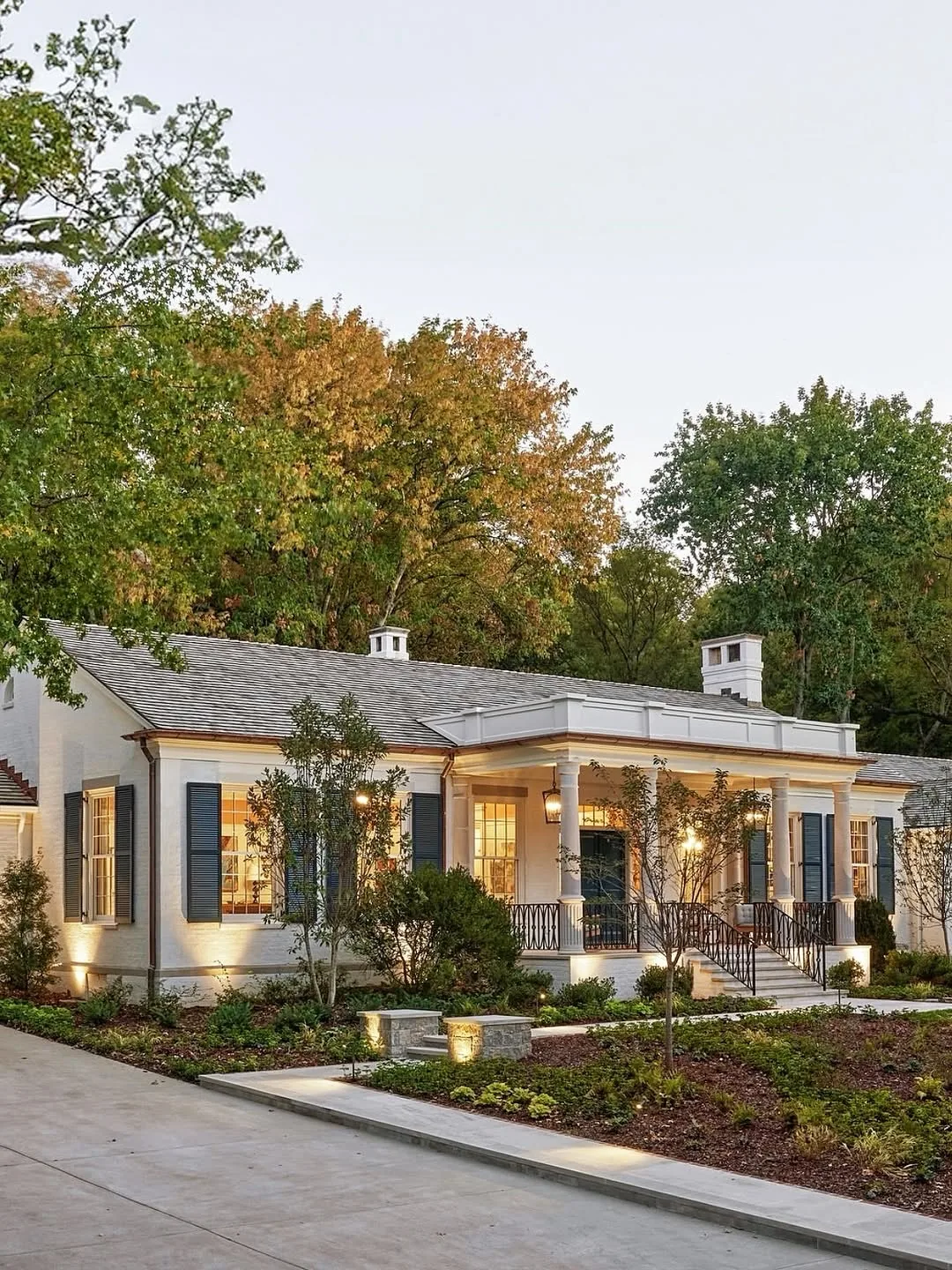 White ranch house with black shutters and cupolas