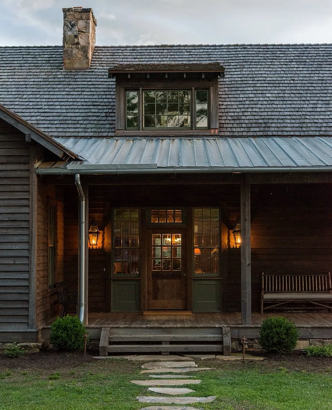 Dark timber lodge with a metal porch roof