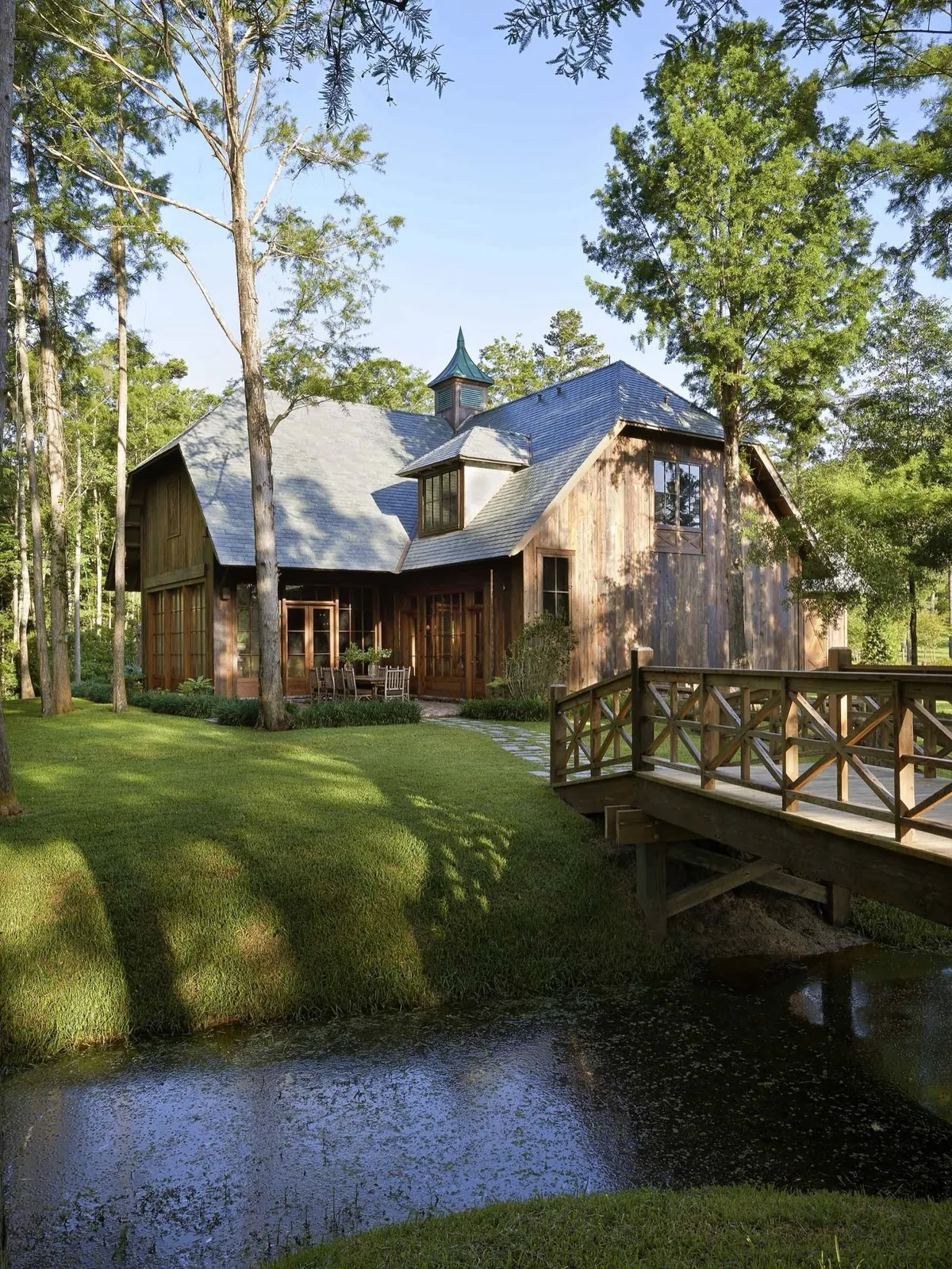 Weathered timber barn house with a wooden bridge