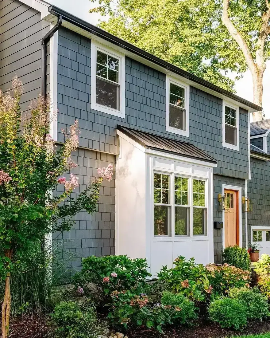 Blue shingle house with copper bay window