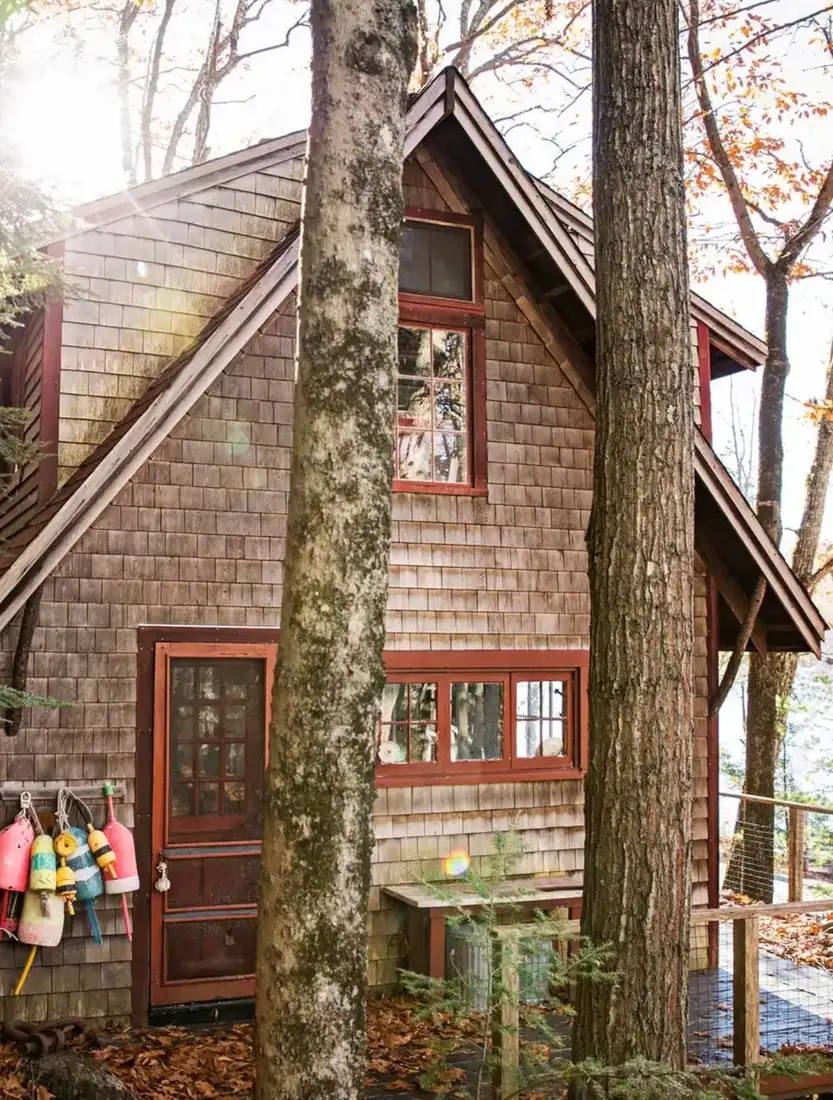 Cedar shingle lake cottage nestled among tall woodland trees