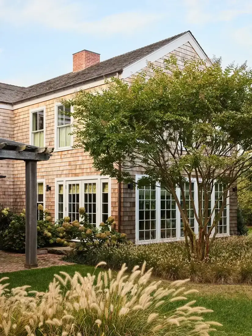 Cedar shingle house with crisp white window trim and a planted front garden