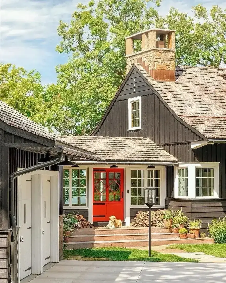 Dark stained shingle cottage with a bright red painted front door