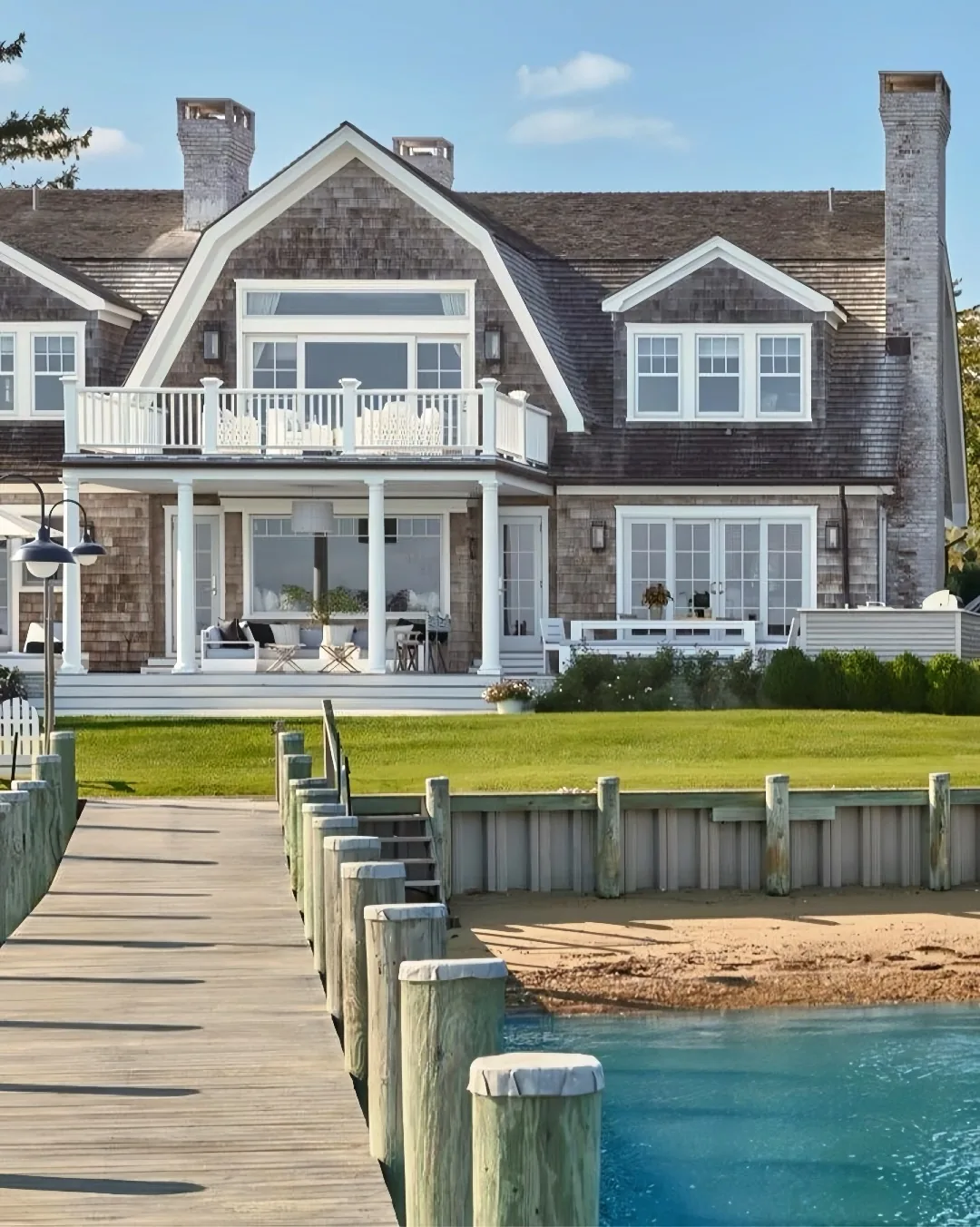 Shingle style waterfront house with a dock and pilings