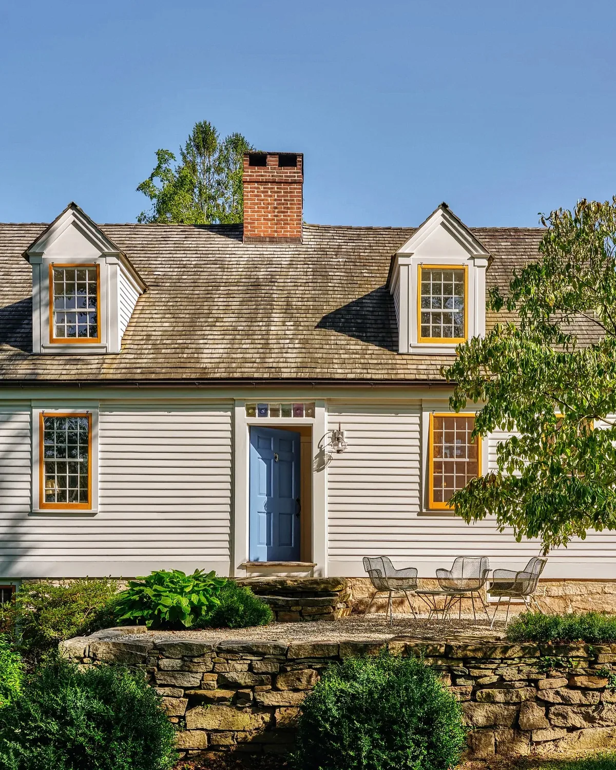 Weathered shingle cape with a blue front door