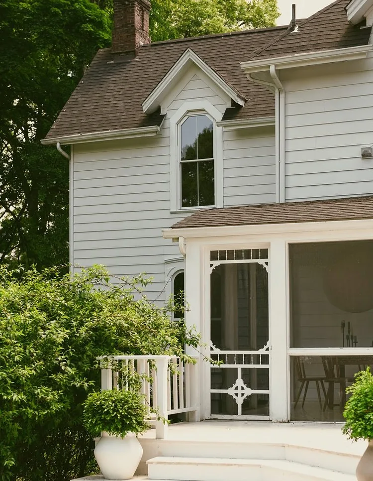 White clapboard screened porch under a shingle gable
