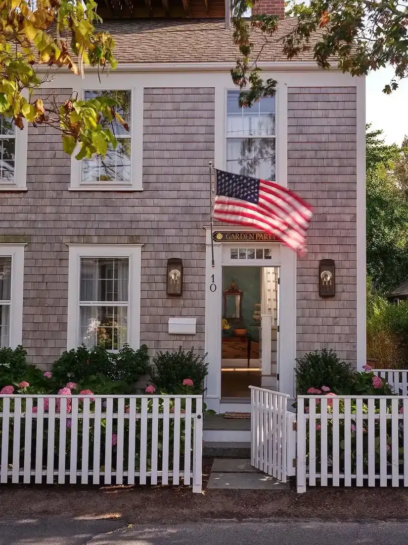 Nantucket shingle cottage with white picket fence and weathered grey shingles
