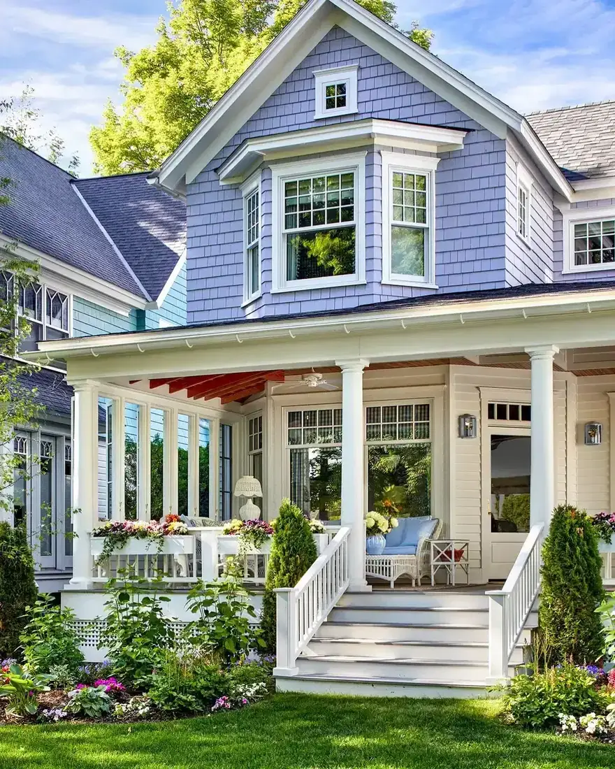 Periwinkle blue shingle Victorian house with wraparound porch