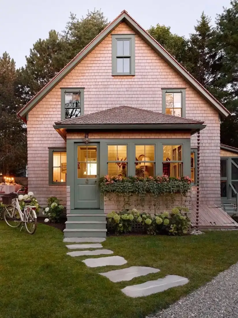 Pink shingle cottage with sage green door and flower window box