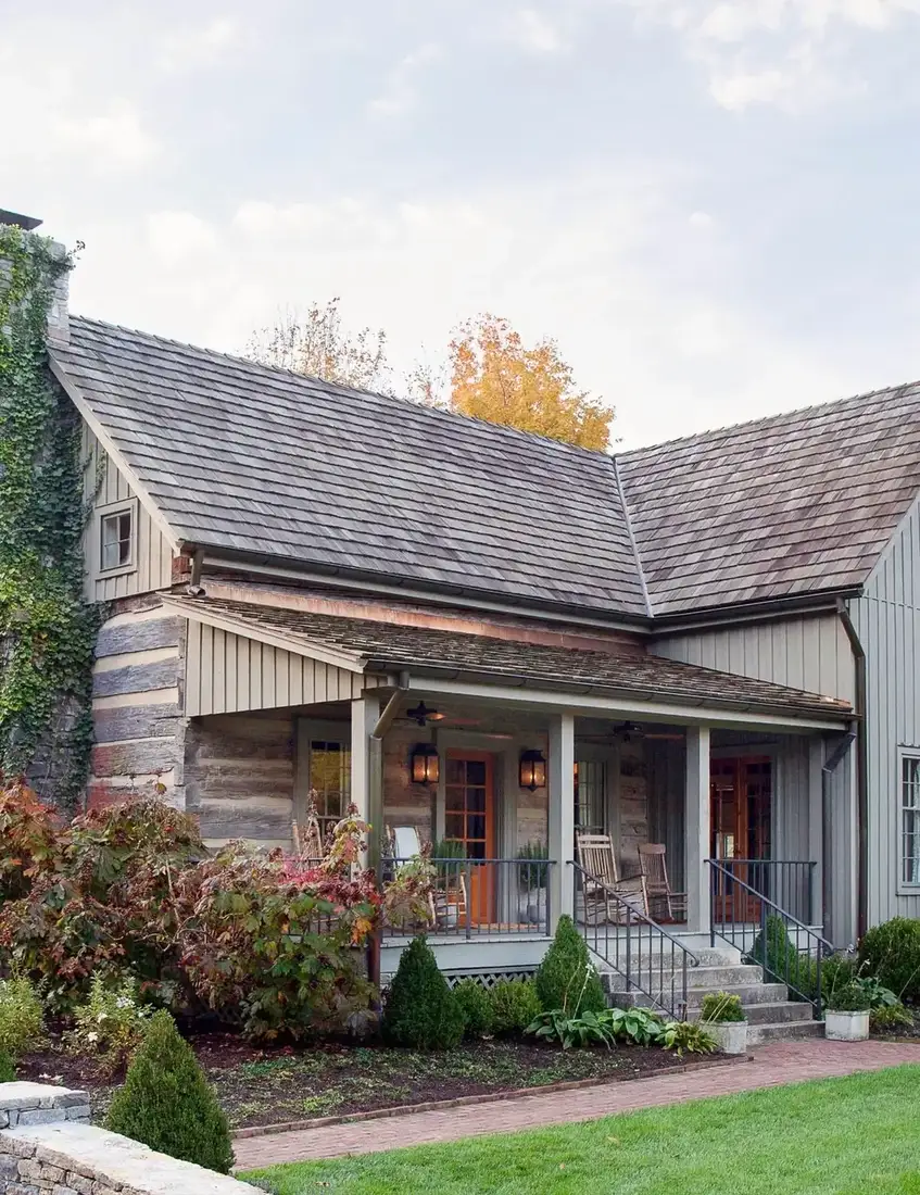 Rustic log cabin with cedar shingle roof and covered front porch