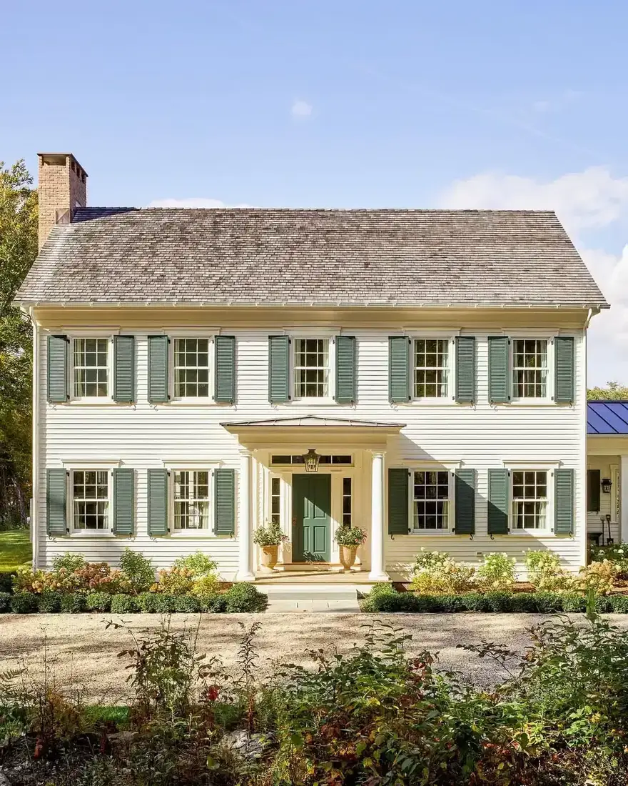 Cream colonial house with sage green shutters and columned portico