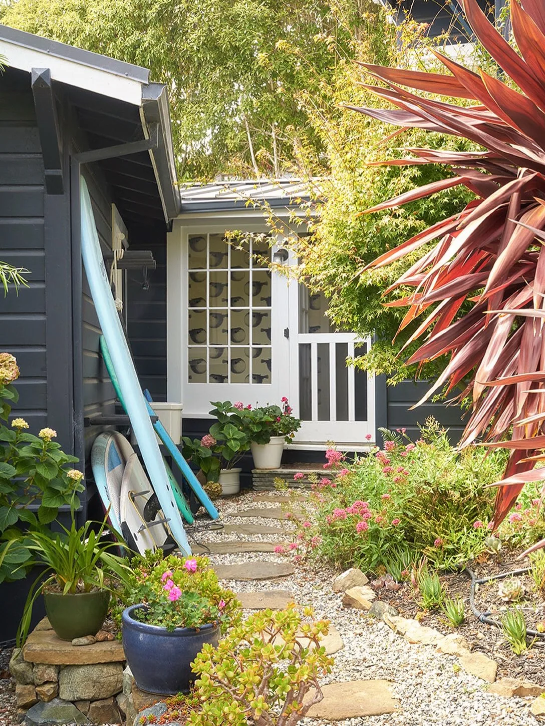 Charcoal cottage with a gravel path