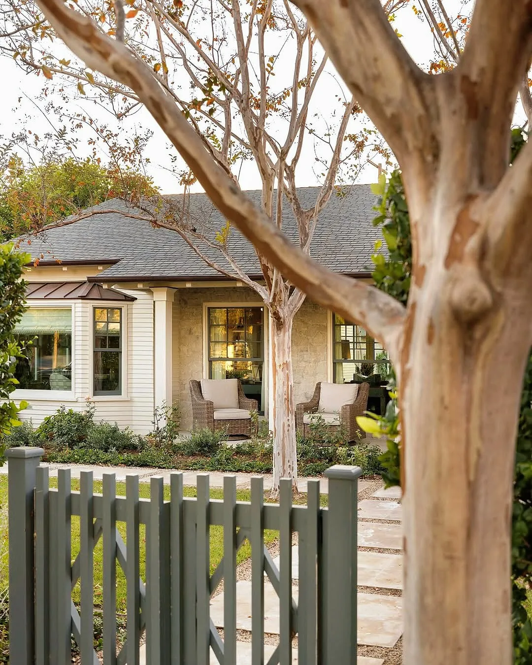 Cream cottage with a copper roof and picket gate