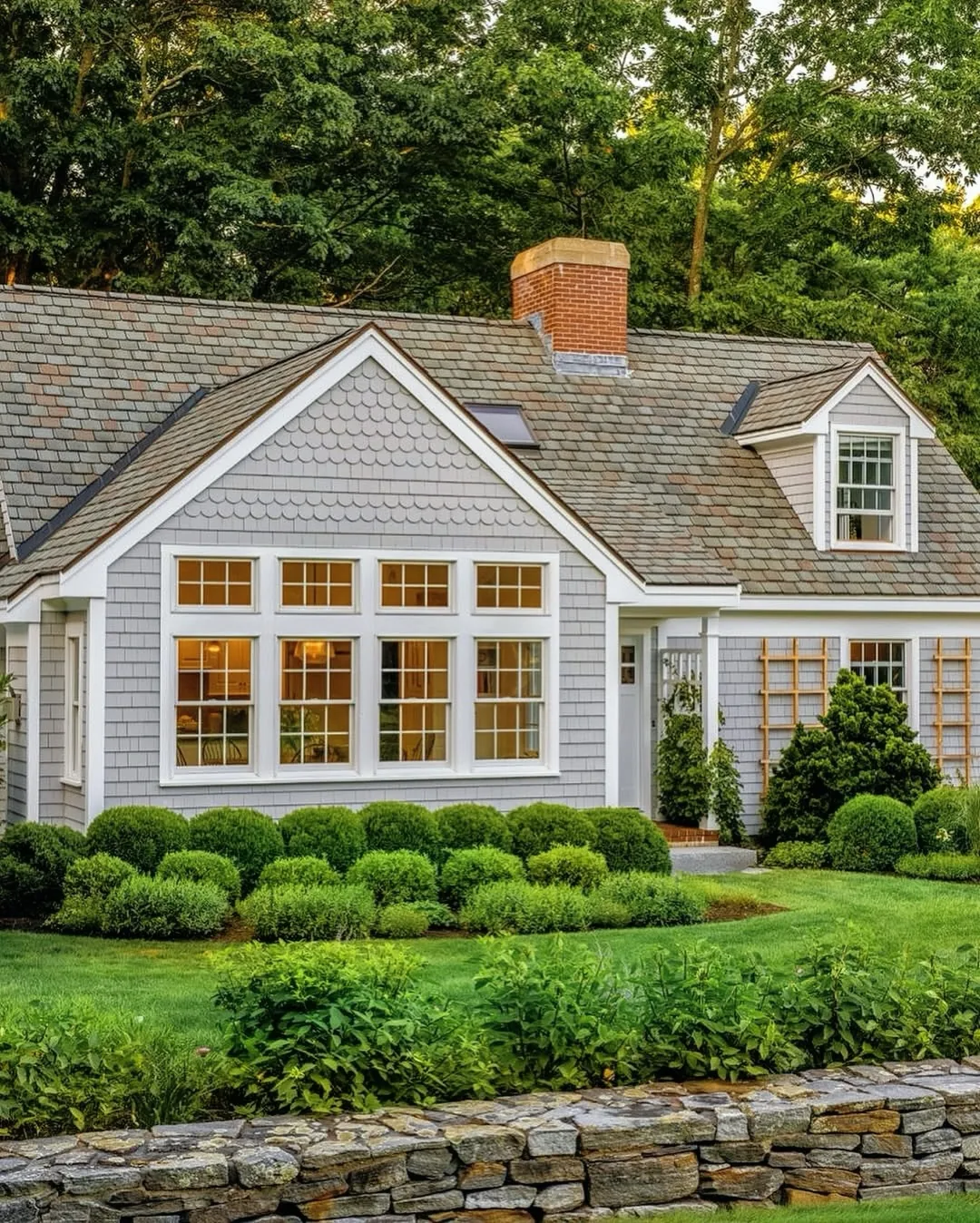 Gray cottage exterior with layered landscaping