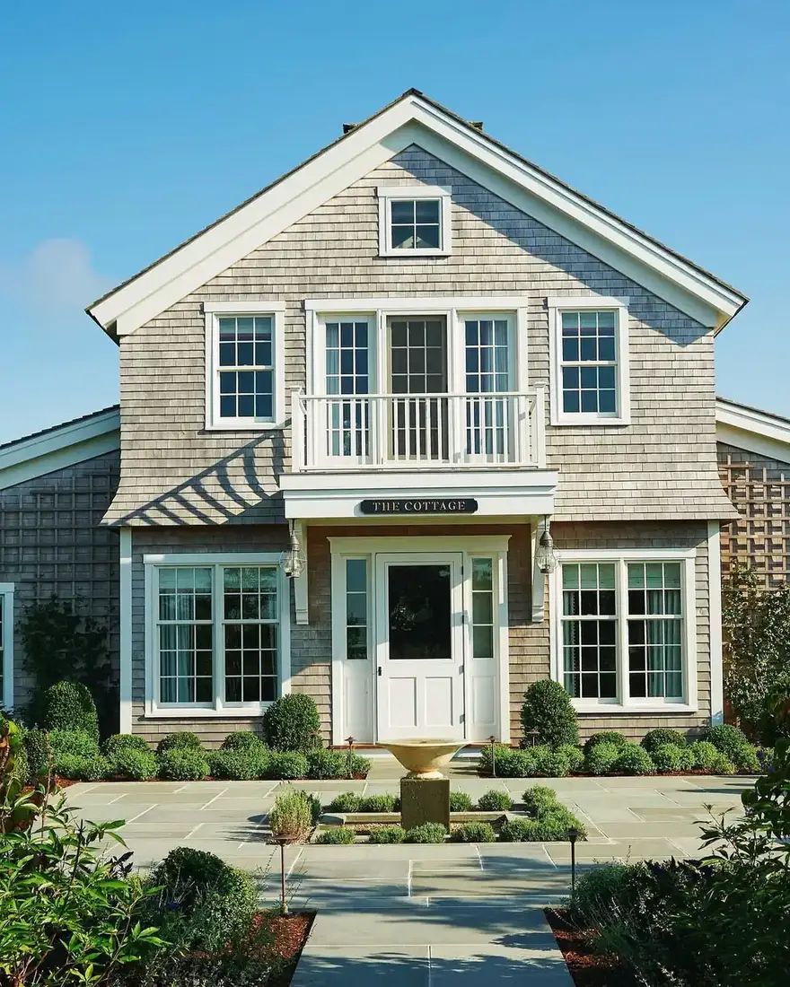 Classic coastal cedar shingle cottage with white trim and gabled roof