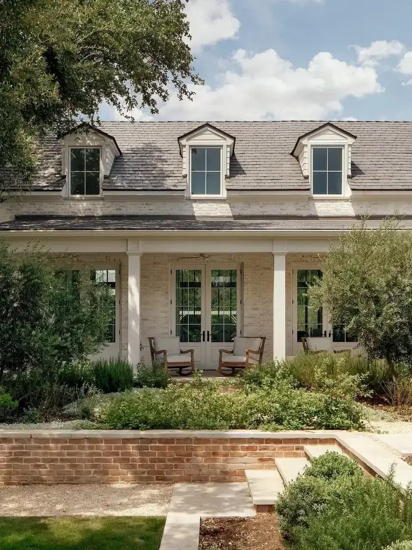 White brick farmhouse with deep front porch and white columns