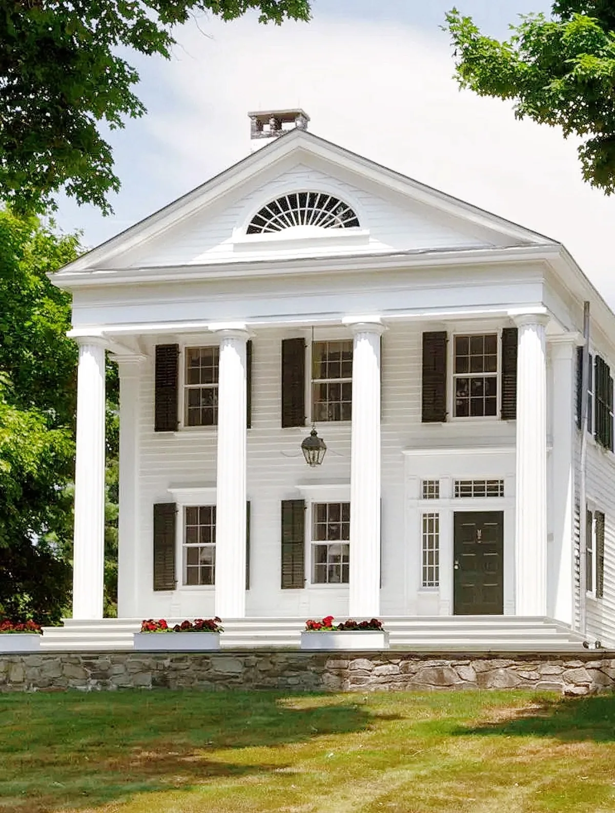 Greek Revival columns with a fanlight and pediment entry