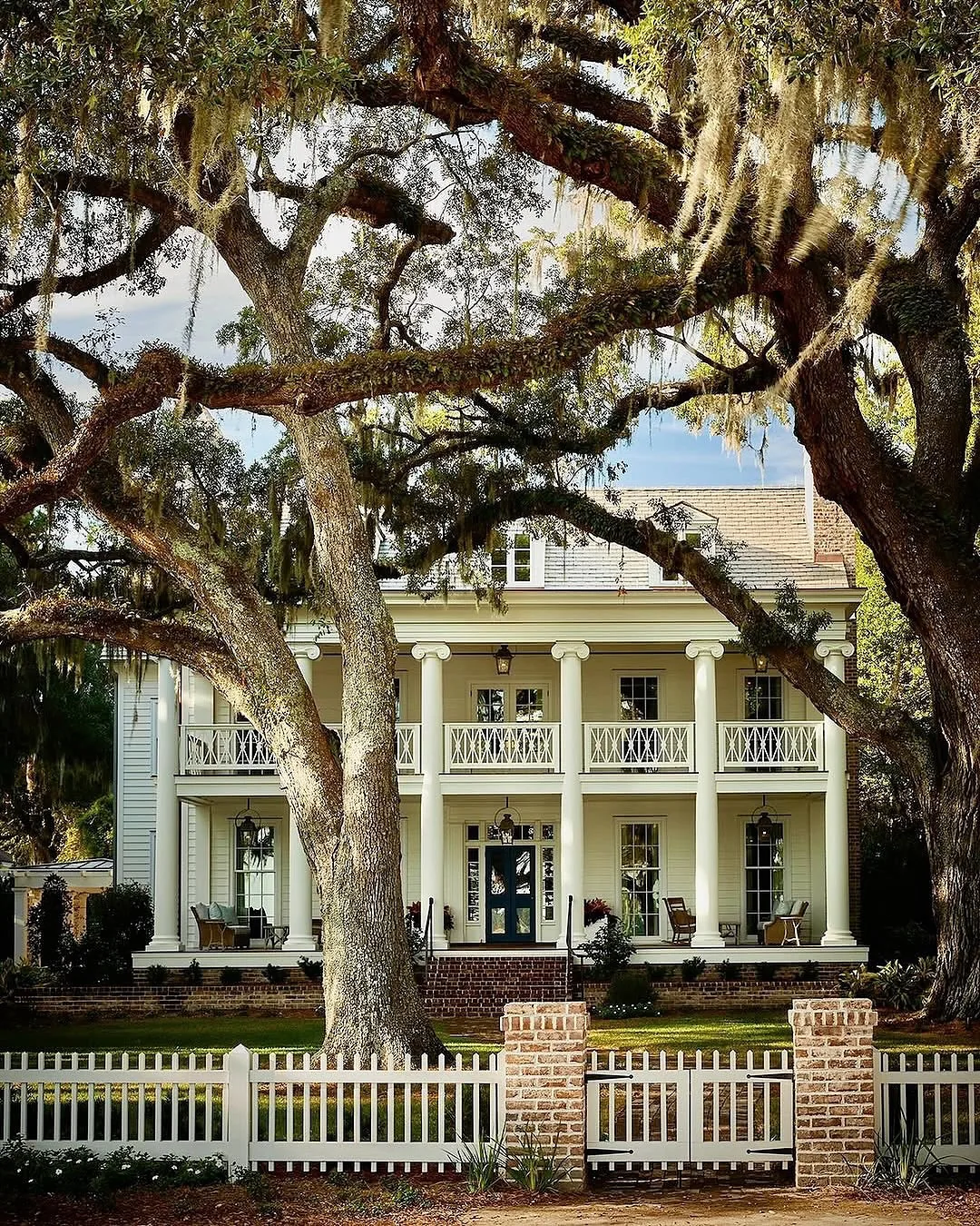 Pale yellow double gallery house under live oaks