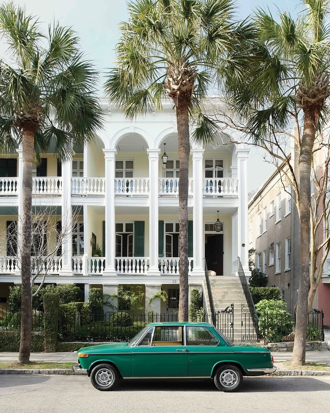 White Charleston double porch with palm trees