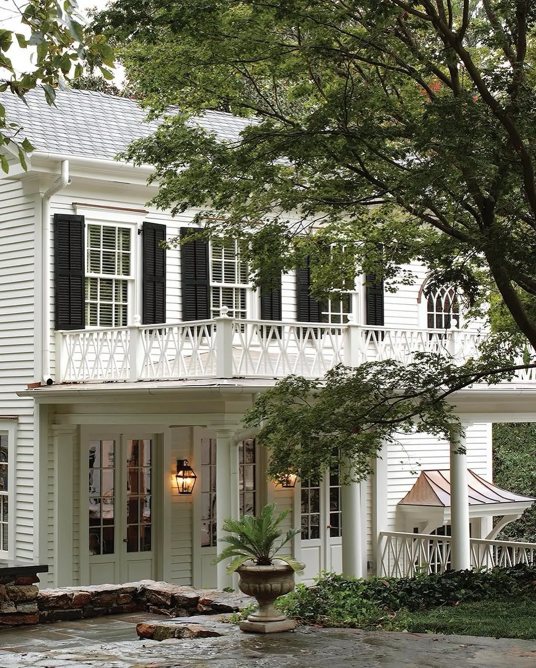White Greek Revival fretwork balcony with lanterns