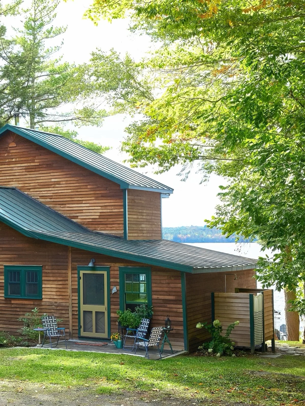 Cedar cottage with green trim at the lake edge