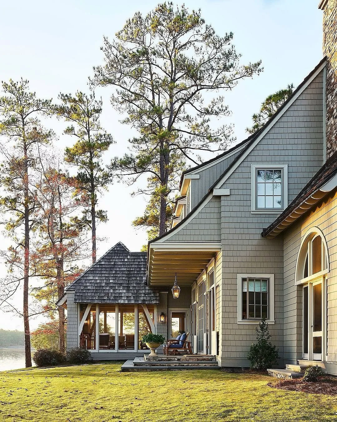 Gray lake house exterior with a backyard sloping to water