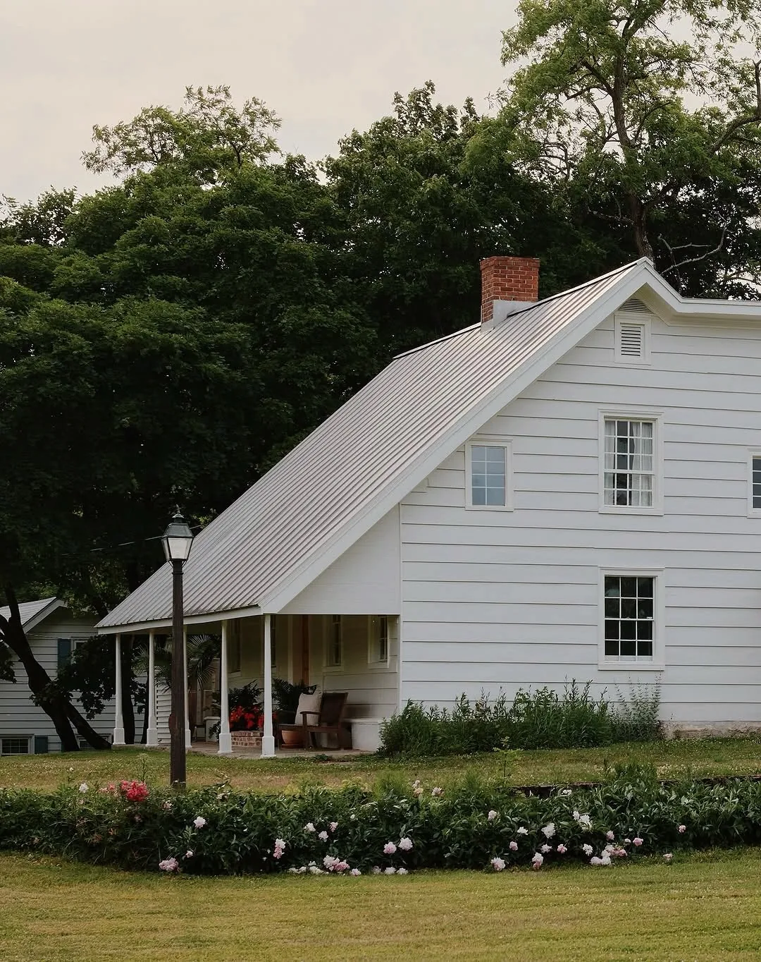White barn style house with a metal roof and front porch