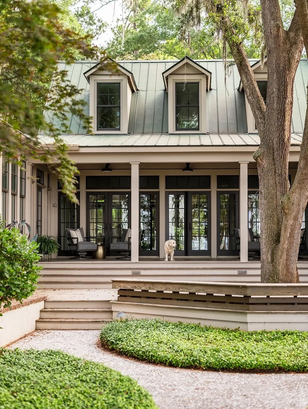 White house with a green metal roof and dormer windows